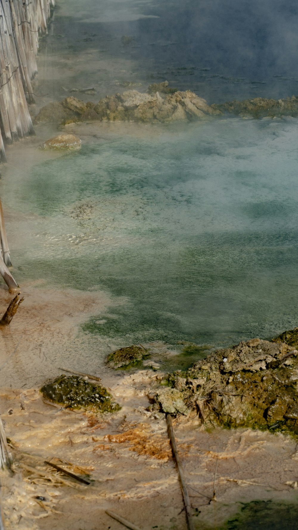 a body of water with rocks and a beach