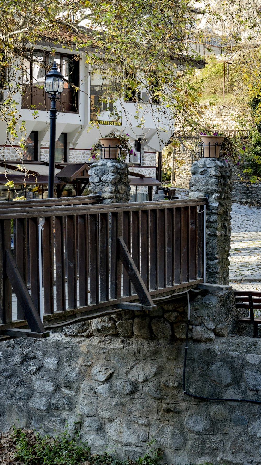 a stone wall with a stone fence and a stone wall with a building in the background