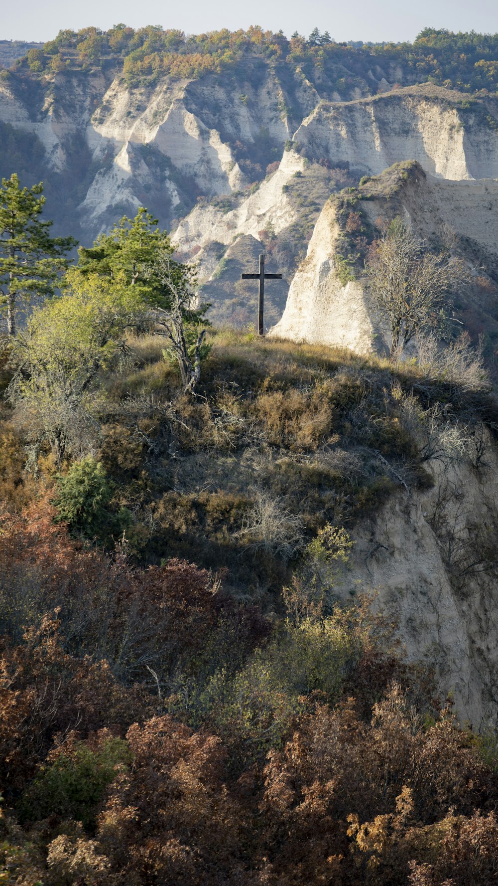 a rocky cliff with a cross on it