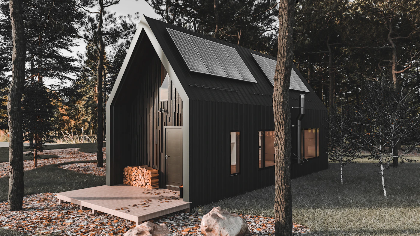 Modern black tiny house with solar panels set among trees