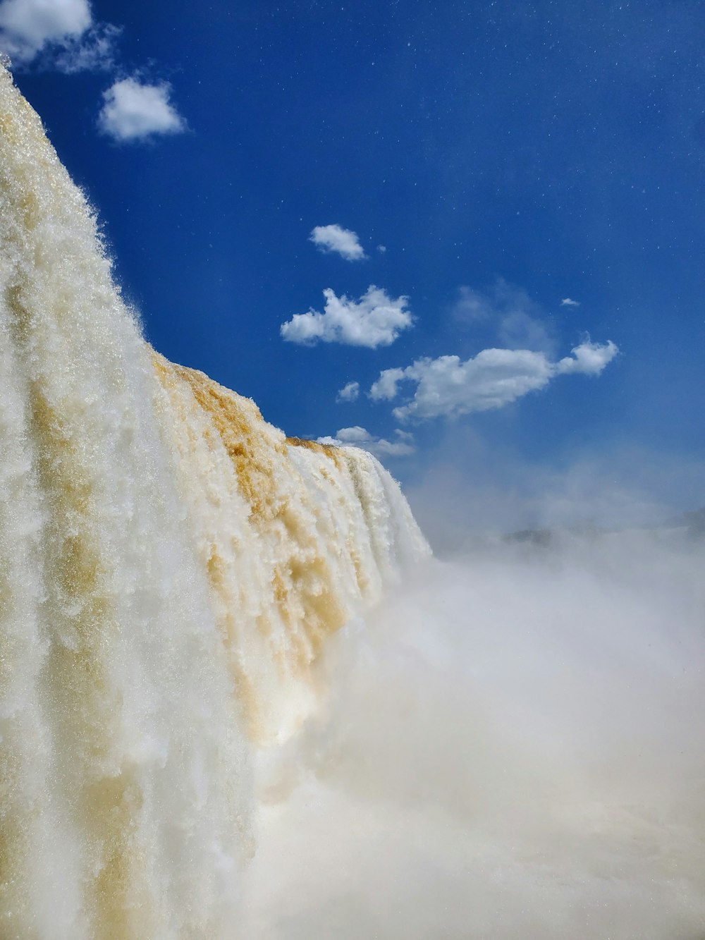 a large waterfall with clouds