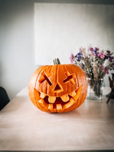 A festive Halloween pumpkin decoration with black and orange colors on a table.