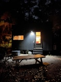 Modern rental cabin with outdoor seating under soft evening light.
