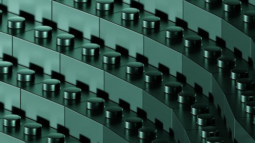 A close-up view of interconnected dark green building blocks with cylindrical connectors, arranged in diagonal rows, creating a repetitive and geometric pattern.