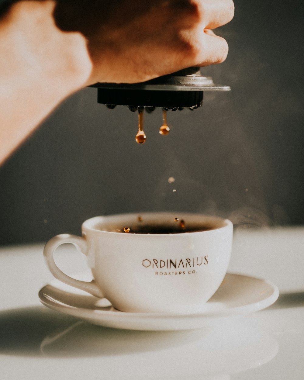 a cup of coffee being poured into a cup