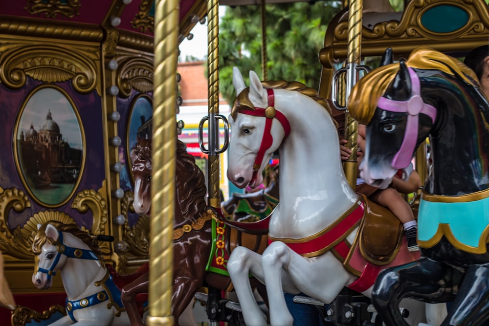 a group of horses ride in a merry go round