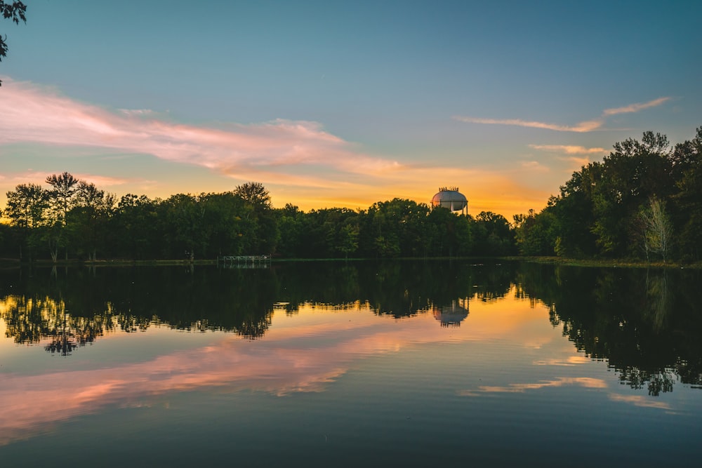 a body of water with trees and a building in the background