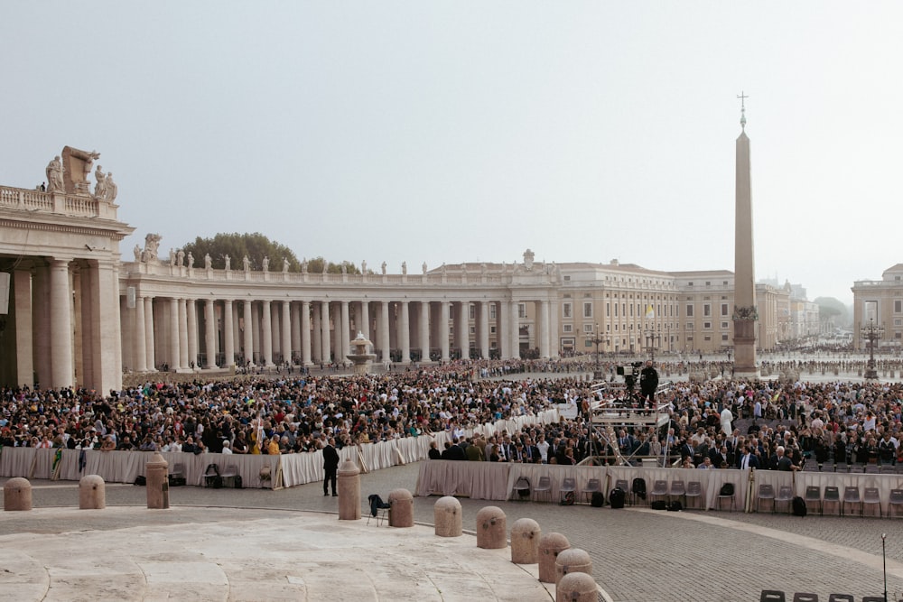 a large crowd of people in front of a white building
