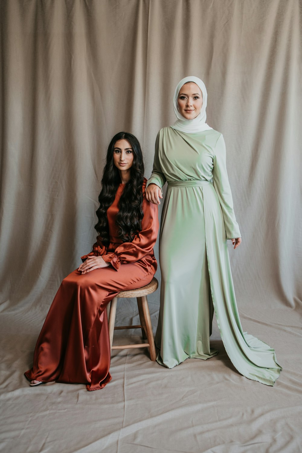 Una mujer sentada junto a una mujer con un vestido verde