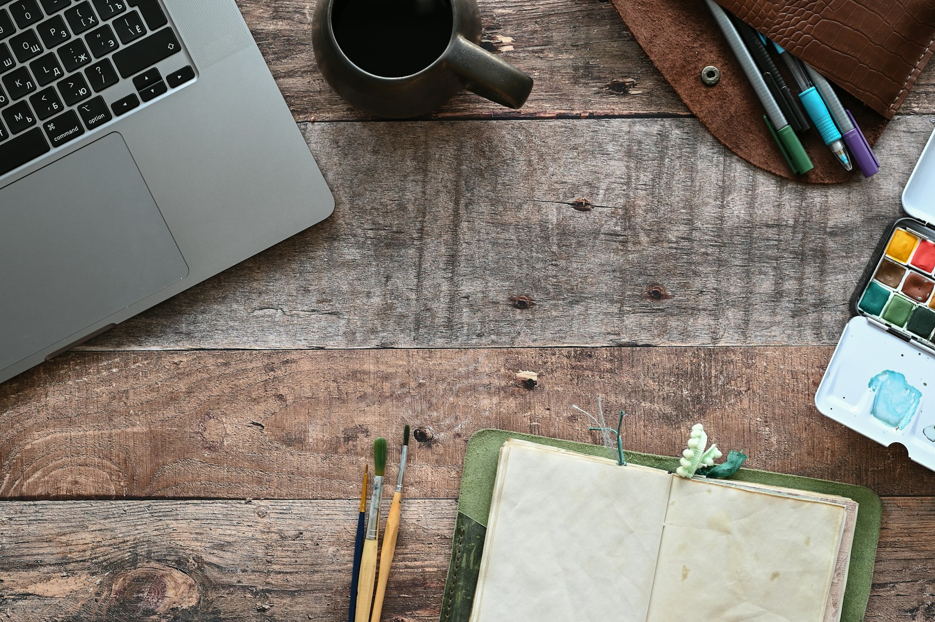 a desk with a laptop and pencils on it