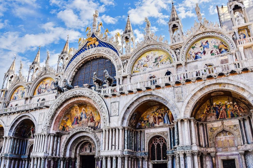 a large ornate building with many arches with St Mark's Basilica in the background