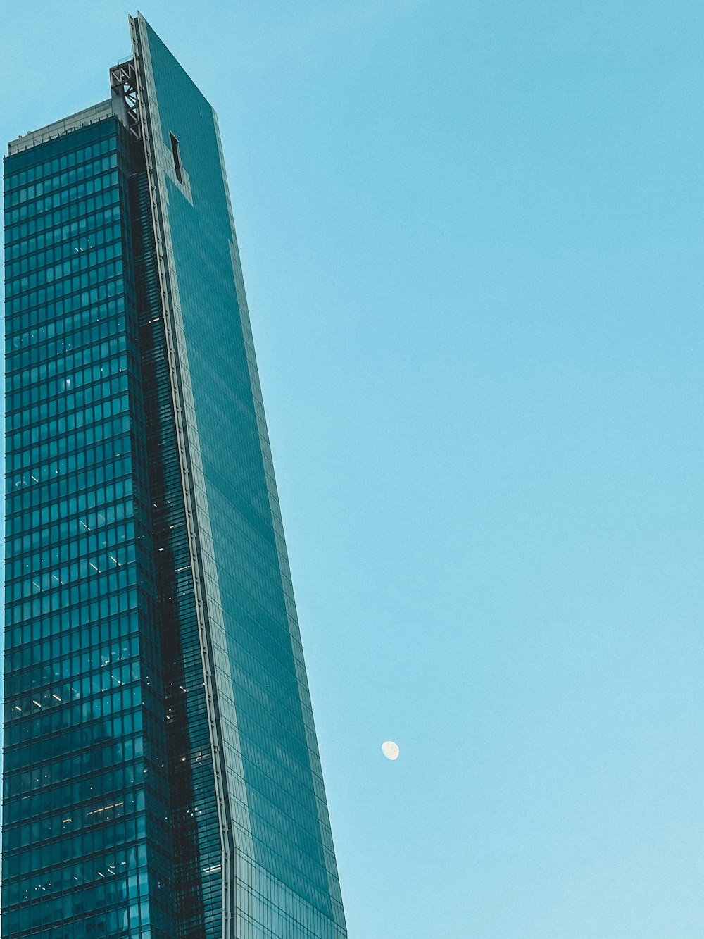 a tall building with a moon in the sky