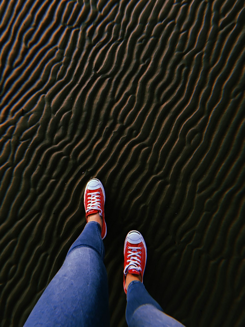 a person's feet on a black and yellow striped surface