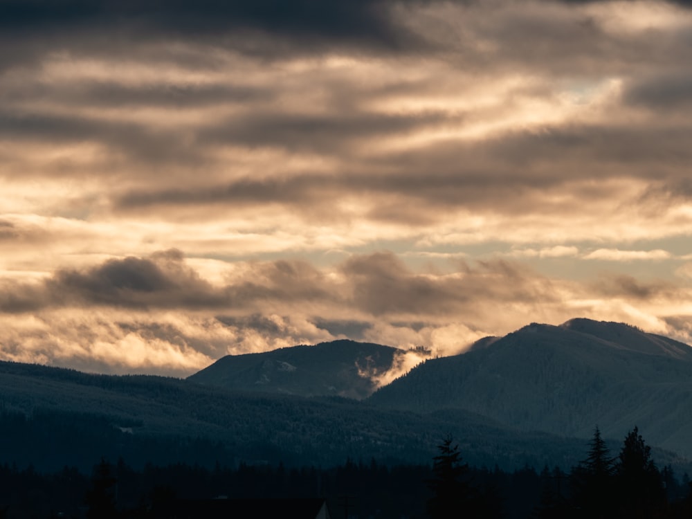 a landscape with mountains and clouds