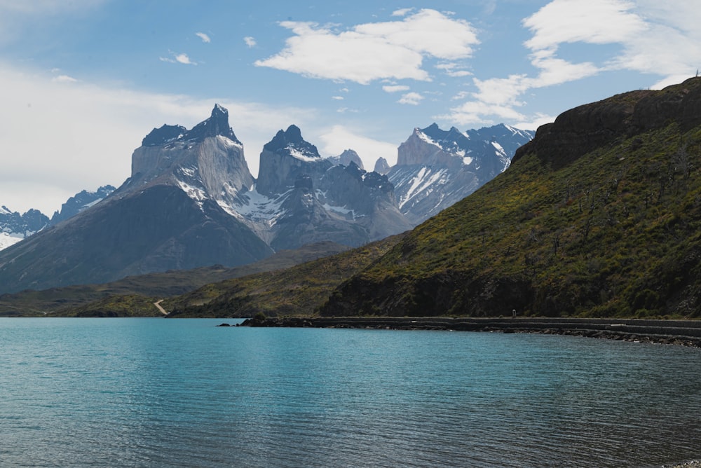 a body of water with mountains in the back with Torres del Paine National Park in the background