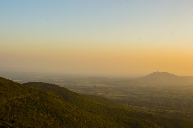 A serene landscape with rolling hills and a sunset.