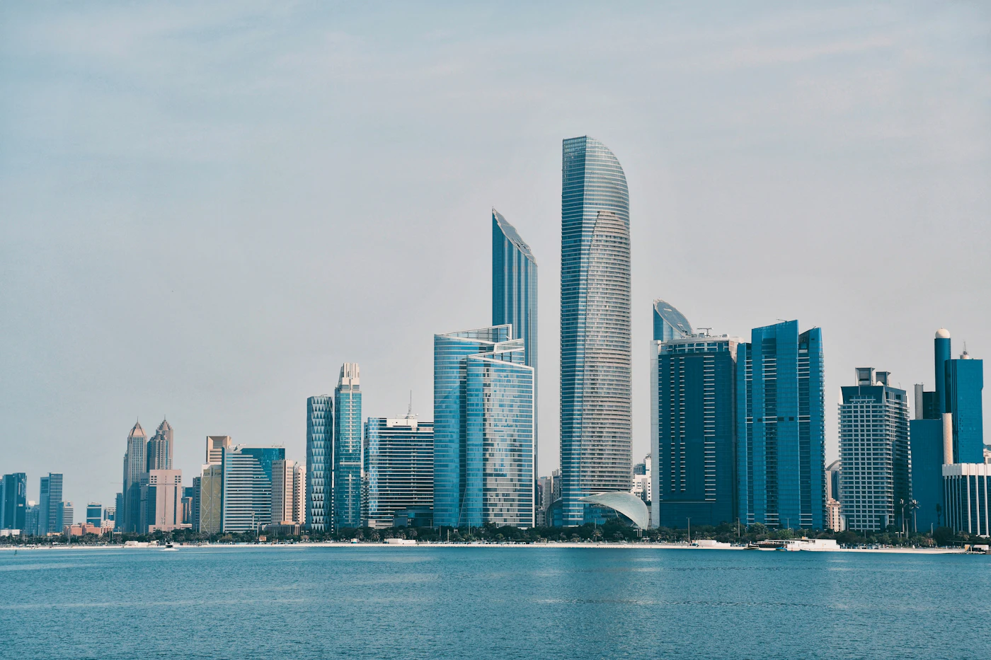 The Abu Dhabi skyline with a body of water in the foreground