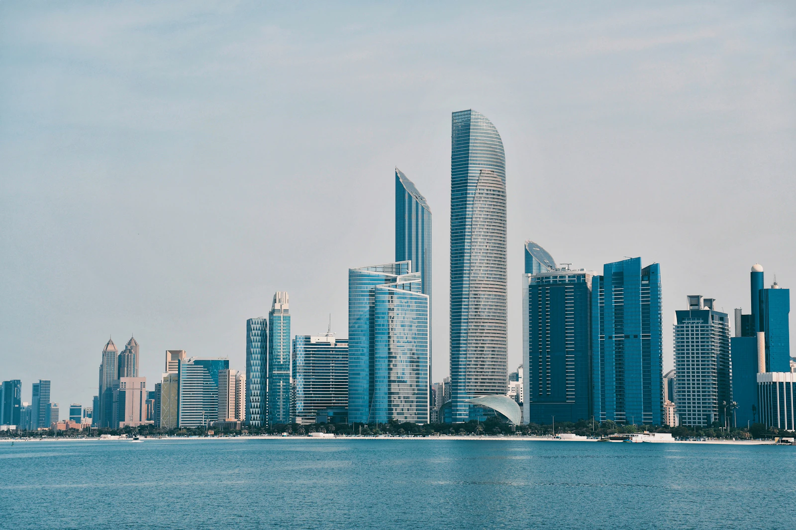 The Abu Dhabi skyline of glass towers viewed across the water from the Corniche
