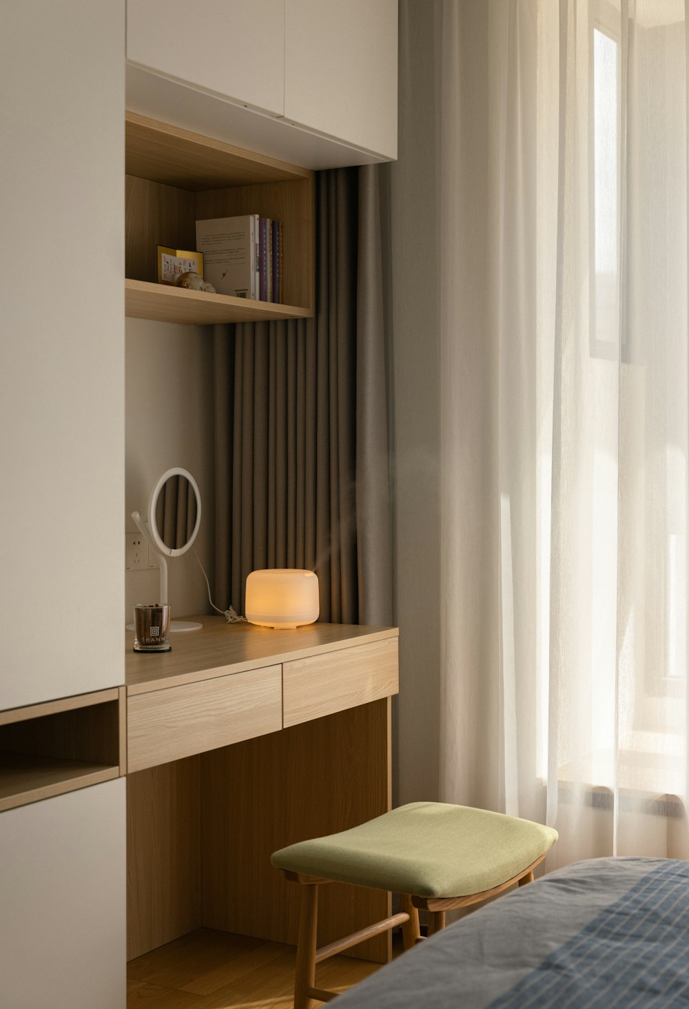 a room with a desk and a shelf with books on it