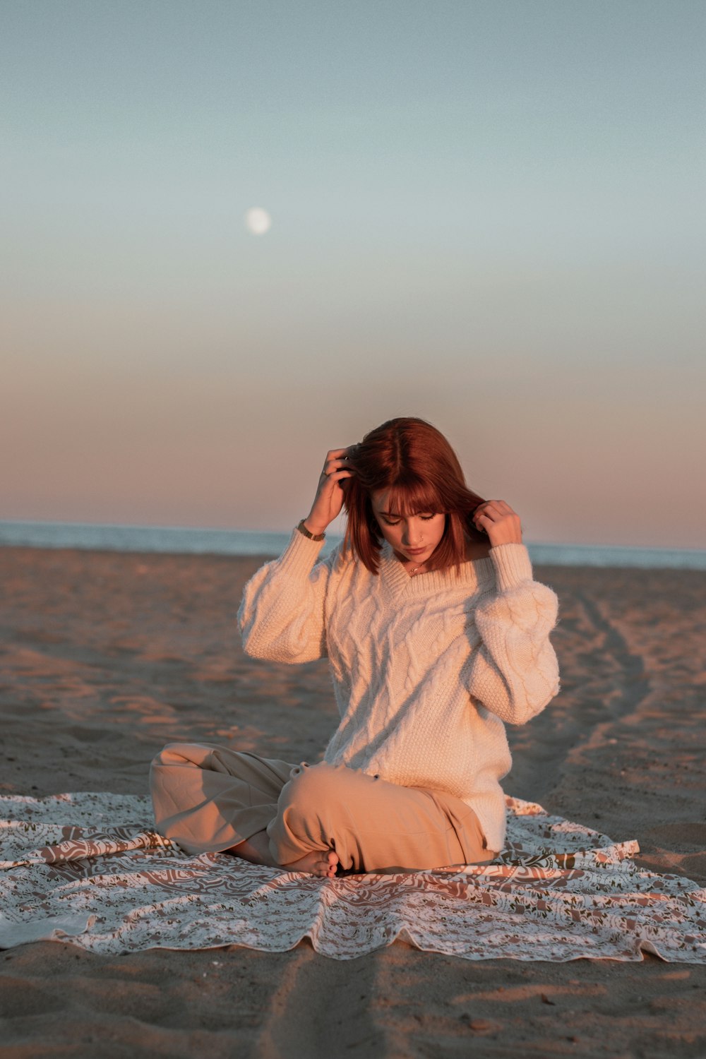 a woman sitting on a beach