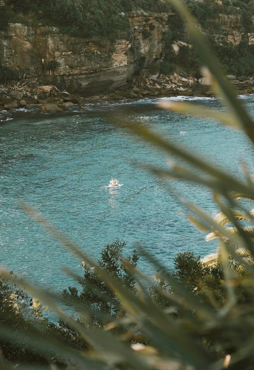 a body of water with a rocky cliff in the background