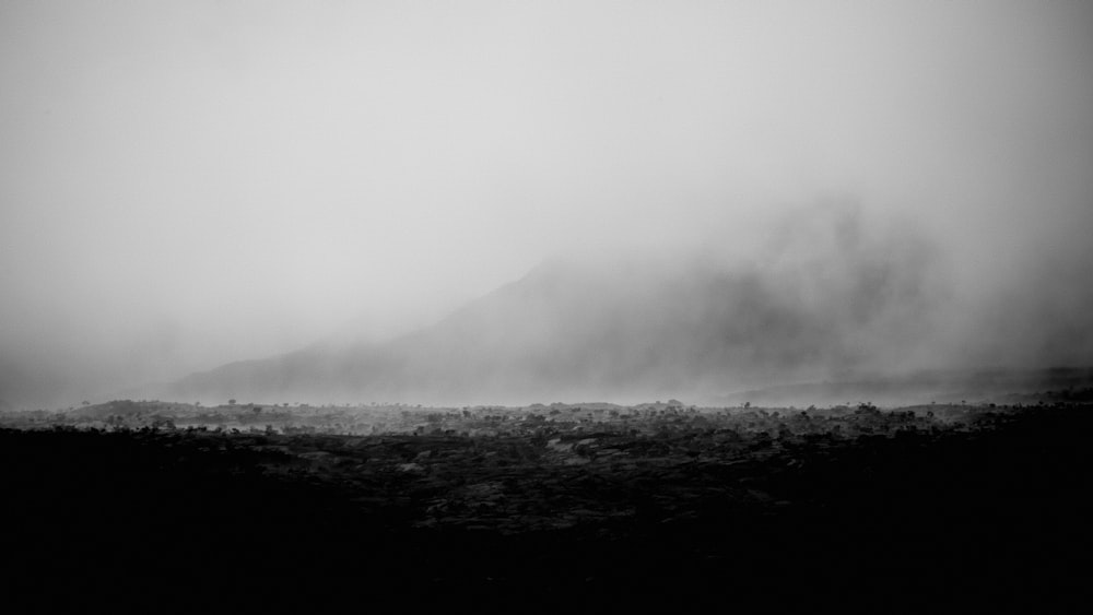 a landscape with hills and fog