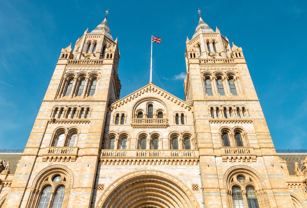 a tall building with a flag on top with Natural History Museum in the background