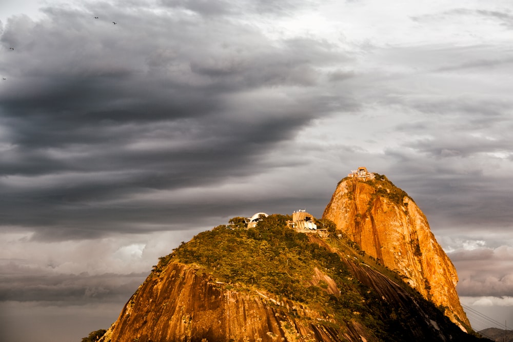 a rocky mountain with clouds above