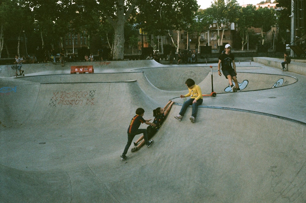 a group of people skateboard at a skate park