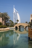 a tall building with Burj Al Arab over a body of water
