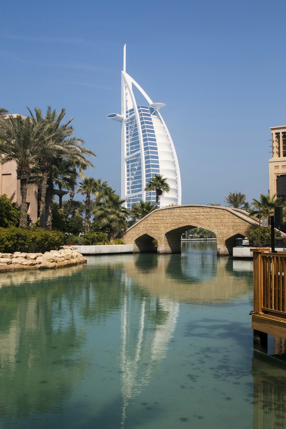 a tall building with Burj Al Arab over a body of water