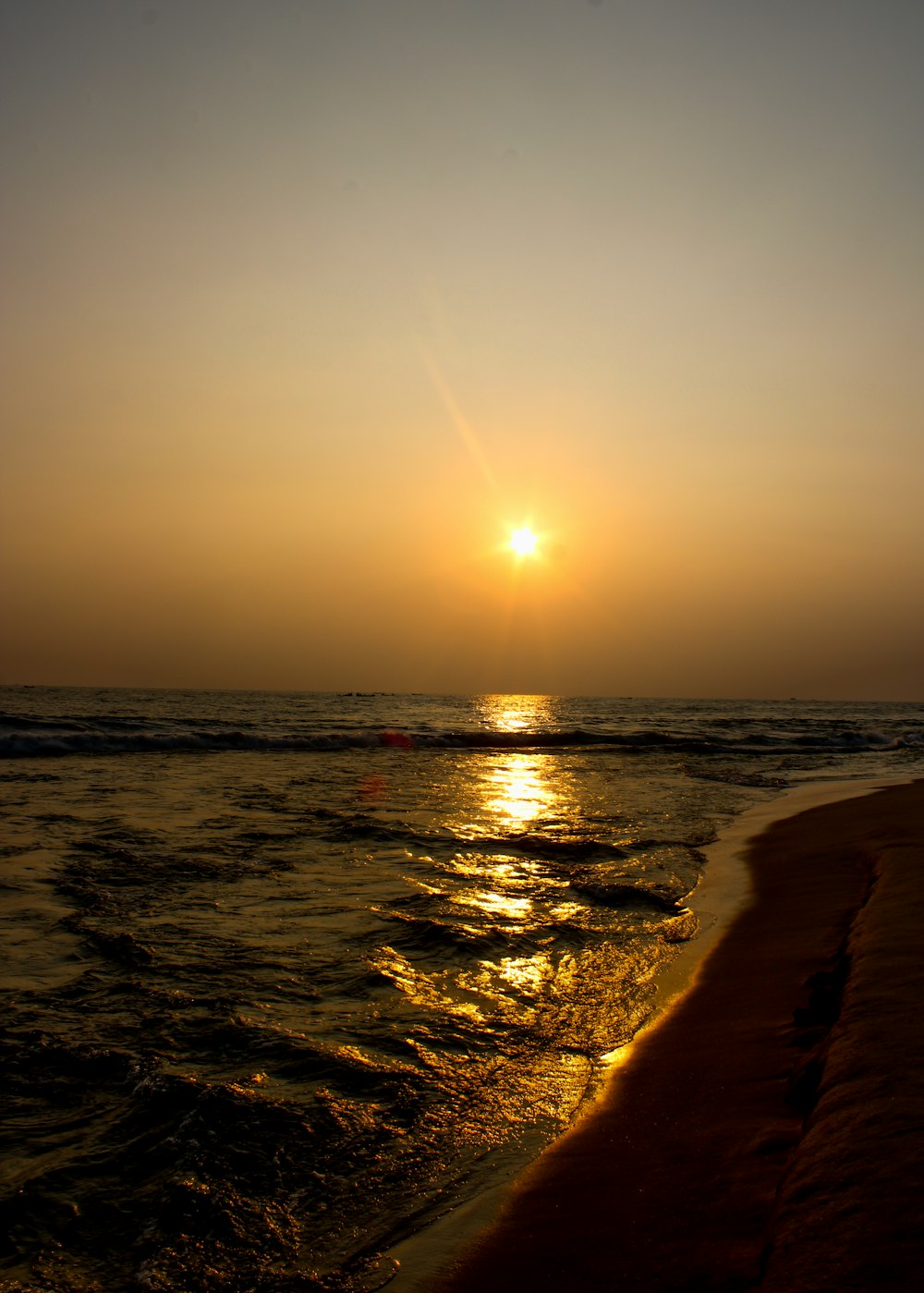 a beach with the sun setting