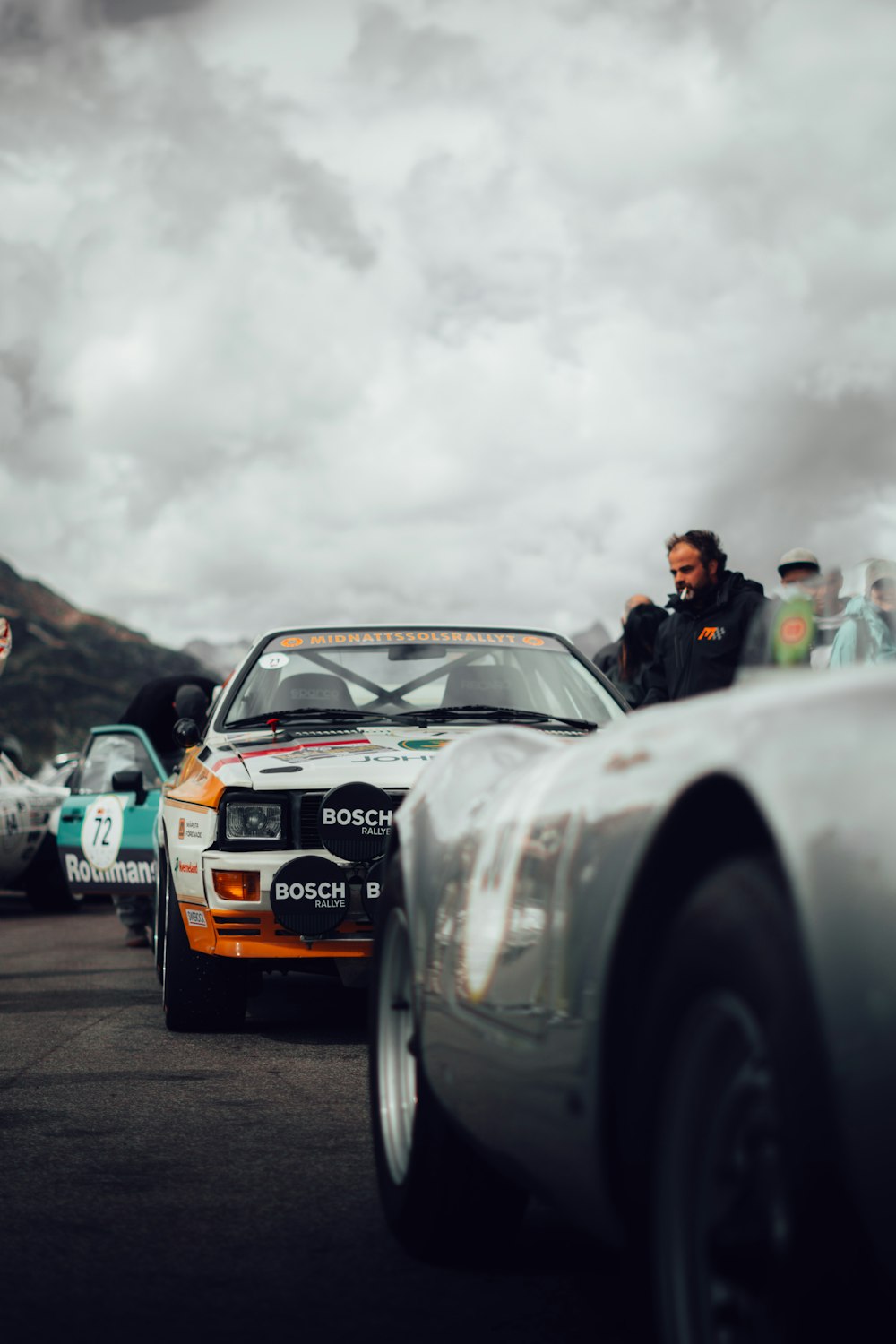 a group of people standing next to a race car