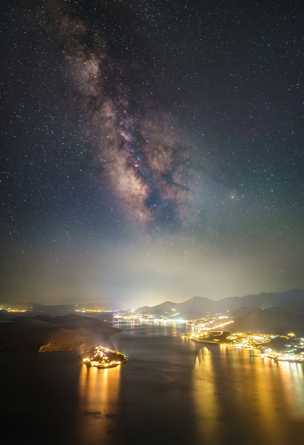 a body of water with a city in the distance at night