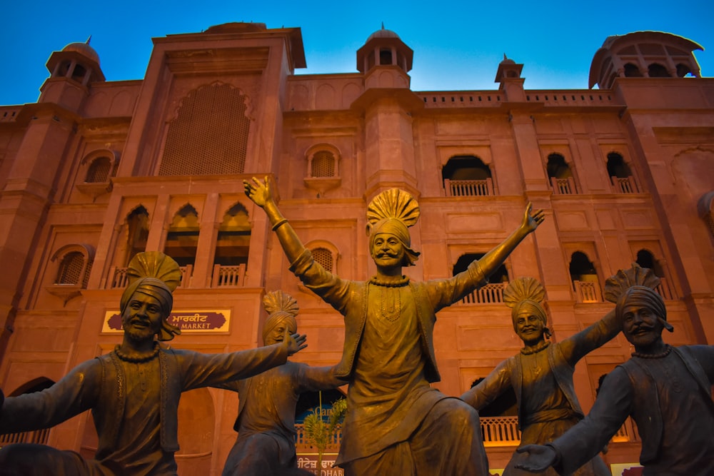 Un grupo de estatuas frente a un edificio