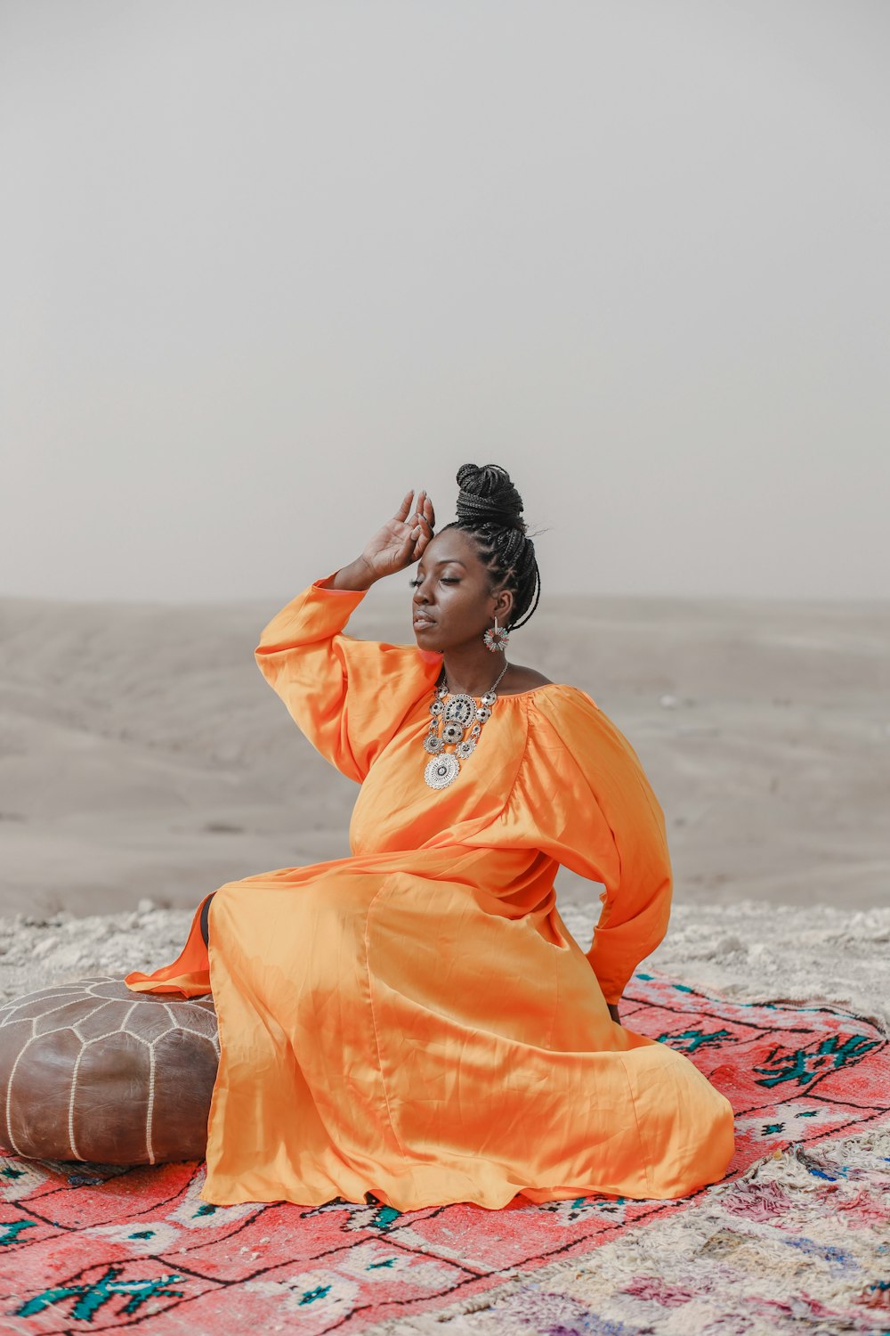 a person sitting on a rug on a beach