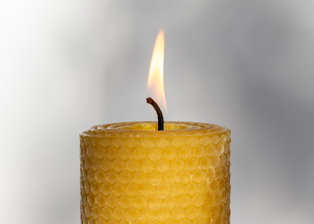 a lit candle in a glass holder