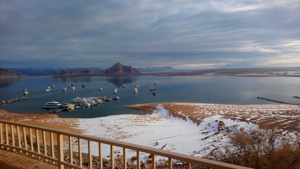 a body of water with boats in it and a beach with snow