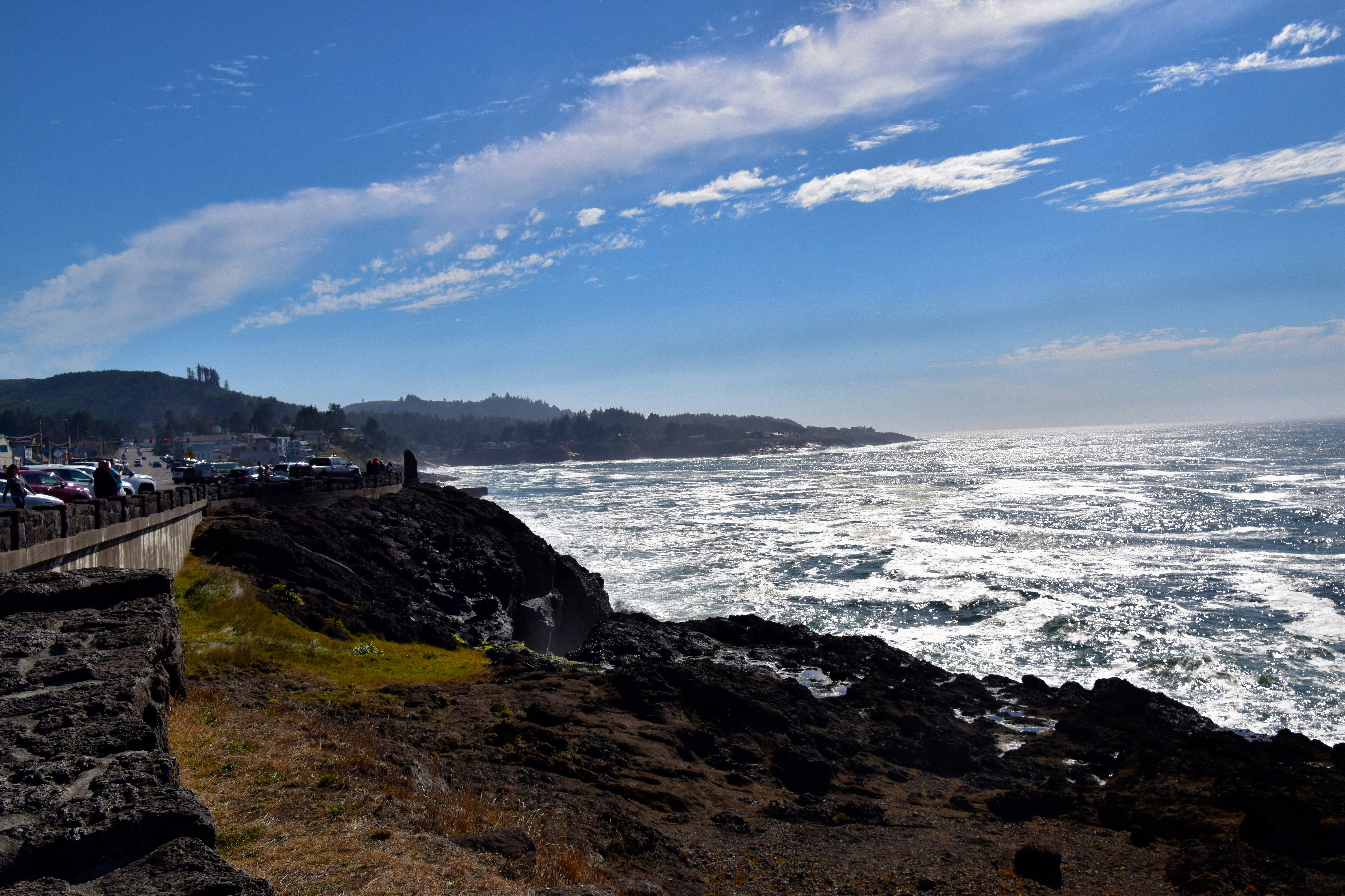 A body of water with a rocky shore and a bridge