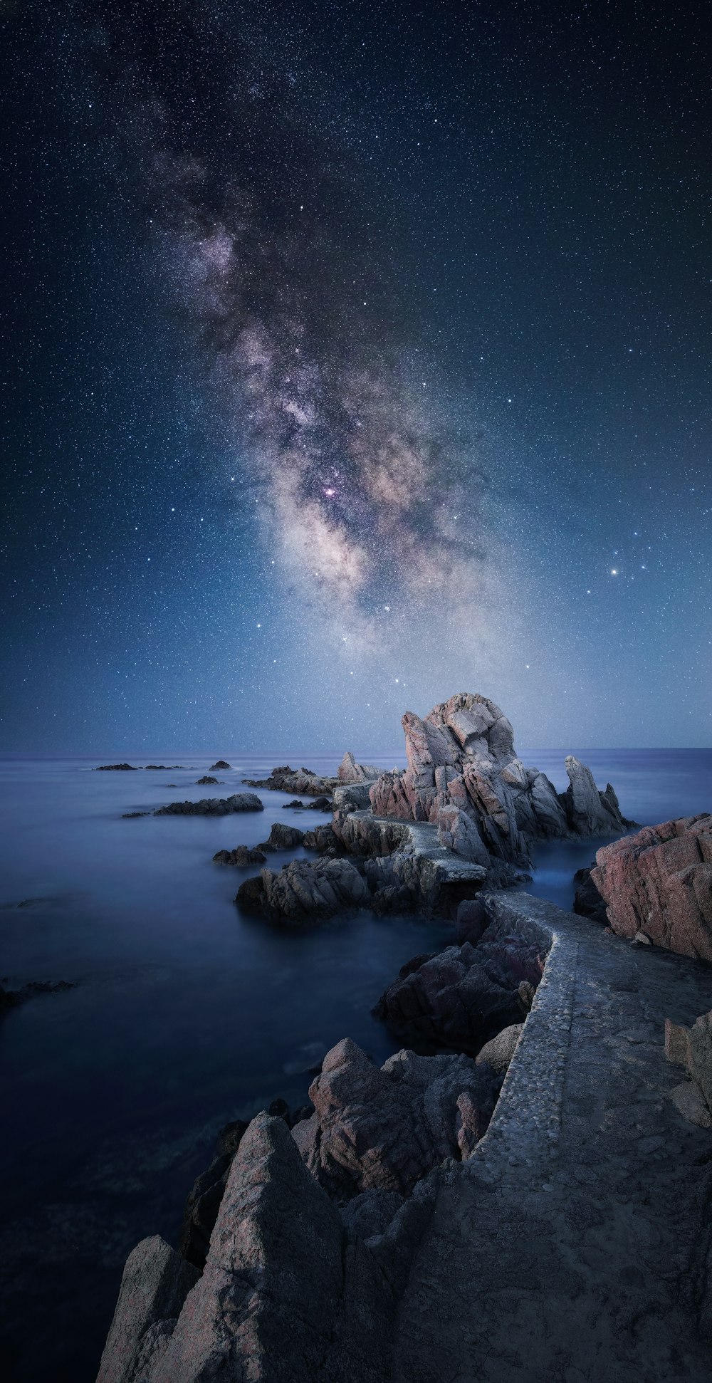 a rocky beach with a starry sky above