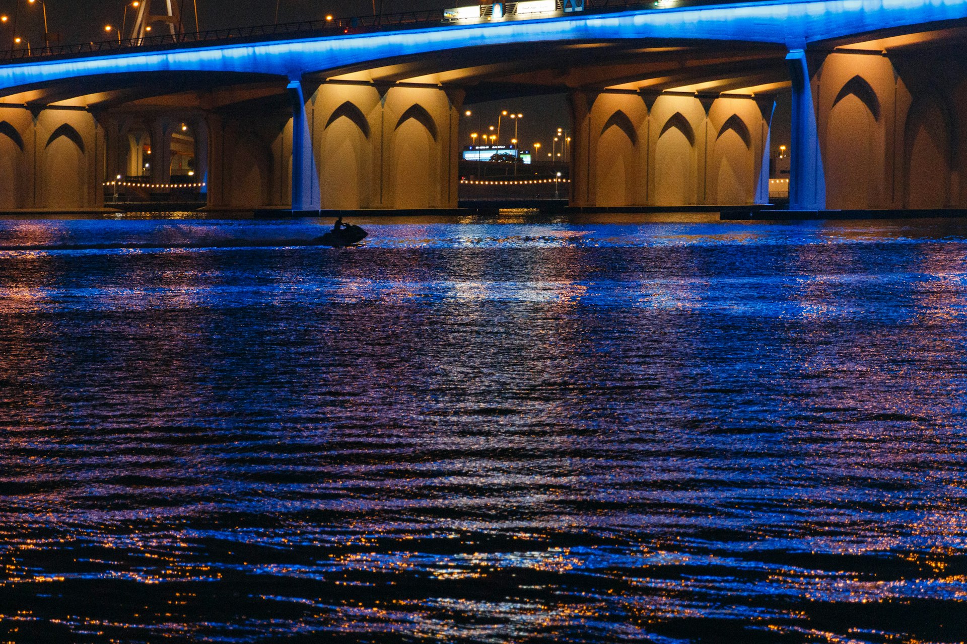 a person swimming in a body of water under a bridge