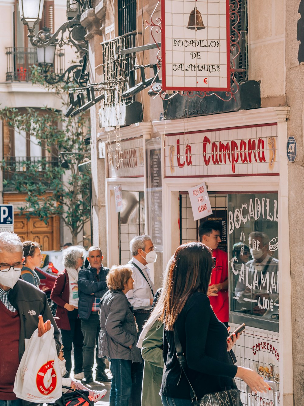 Un grupo de personas de pie fuera de una tienda