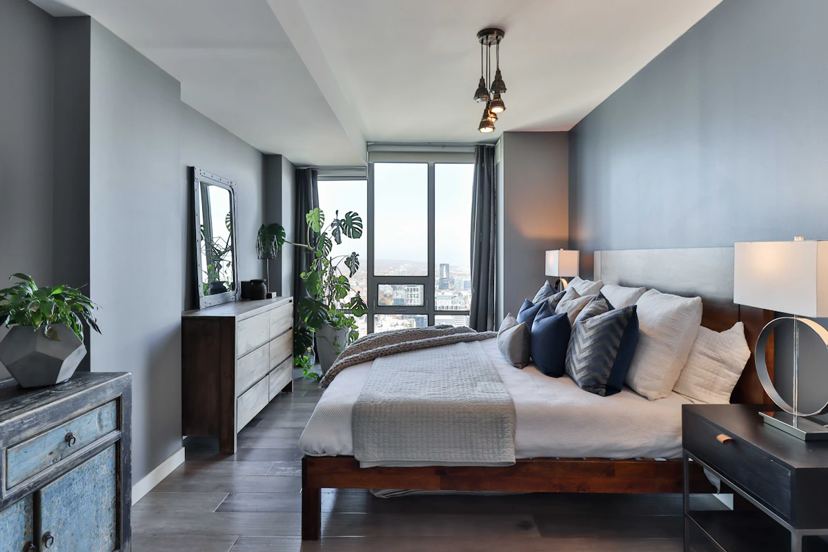 Dark-wood bedroom floor with tall windows along one wall.