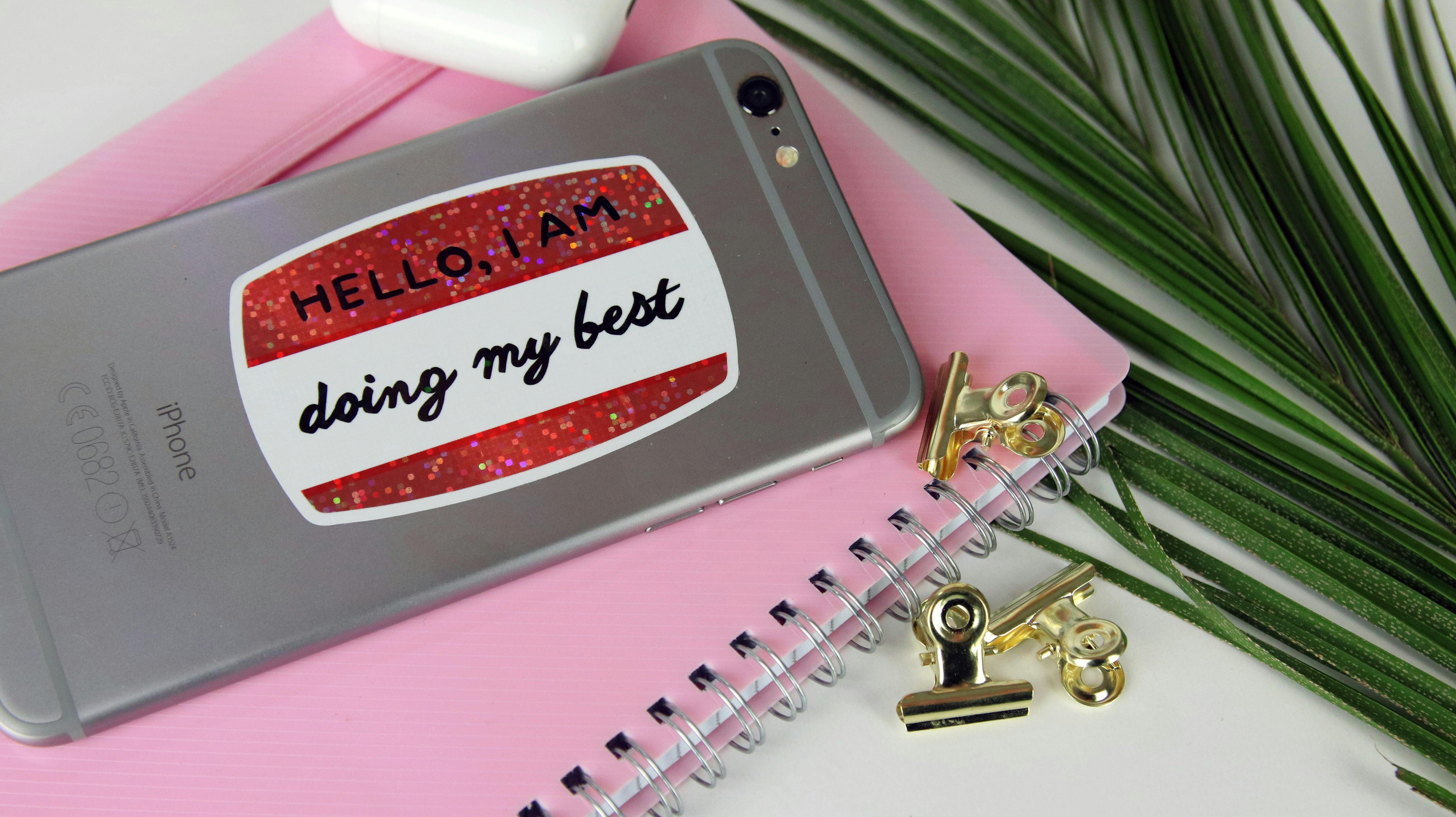 Die cut glitter sticker with custom design applied to a silver phone