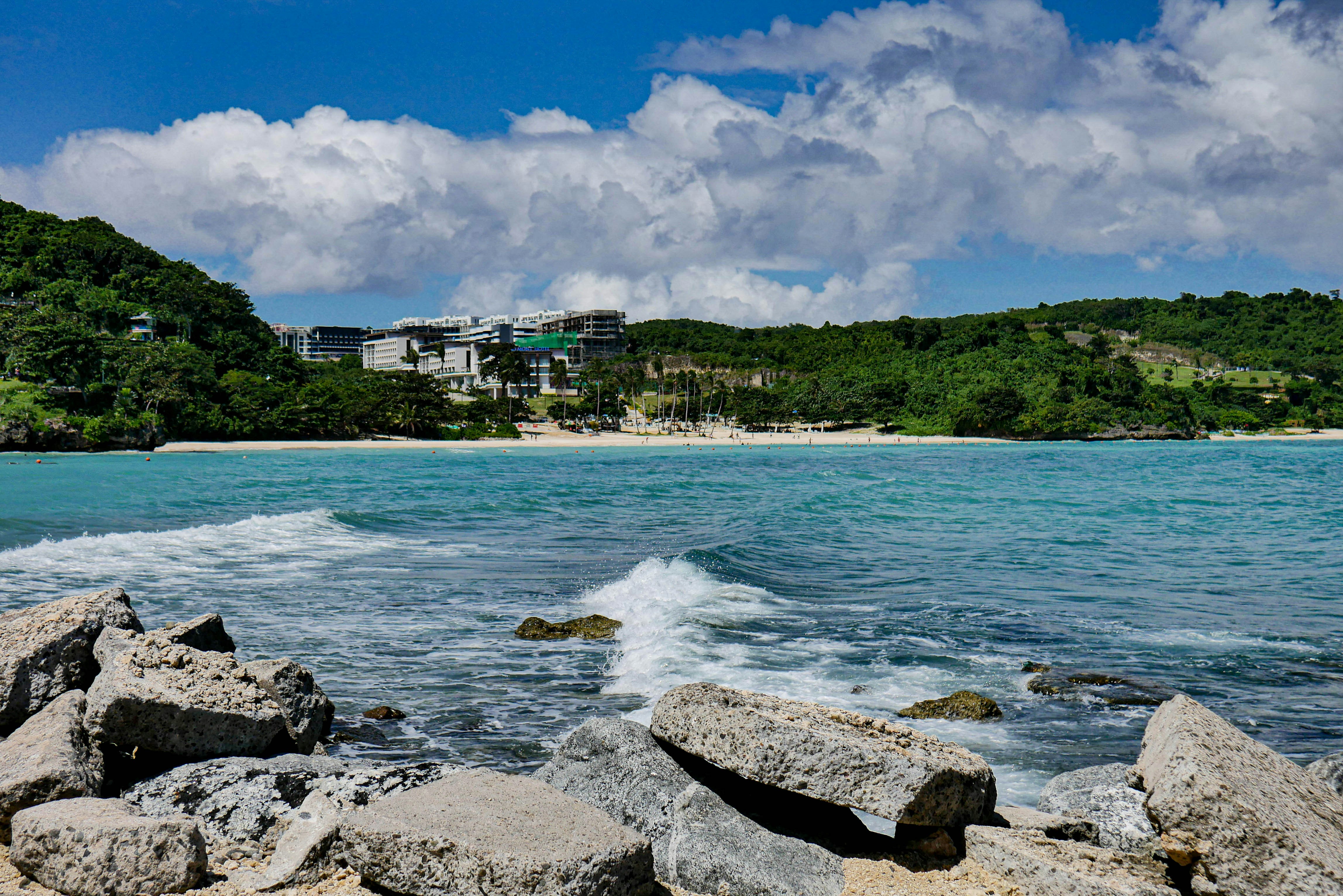a rocky beach with a building in the background