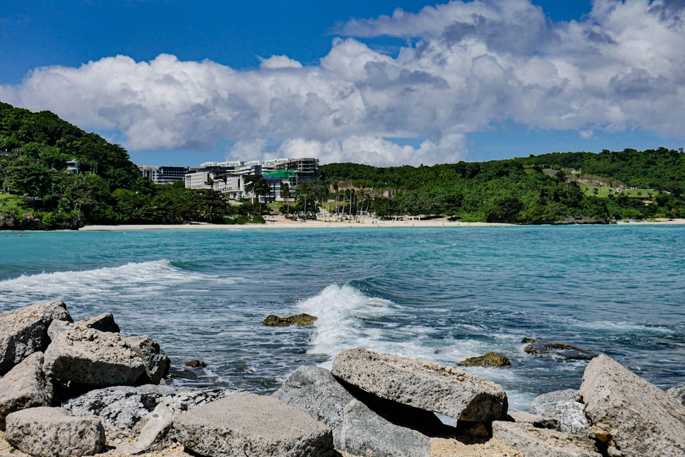 a rocky beach with a building in the background