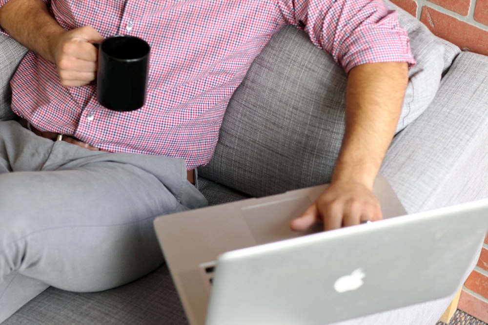 a person sitting on a couch with a laptop