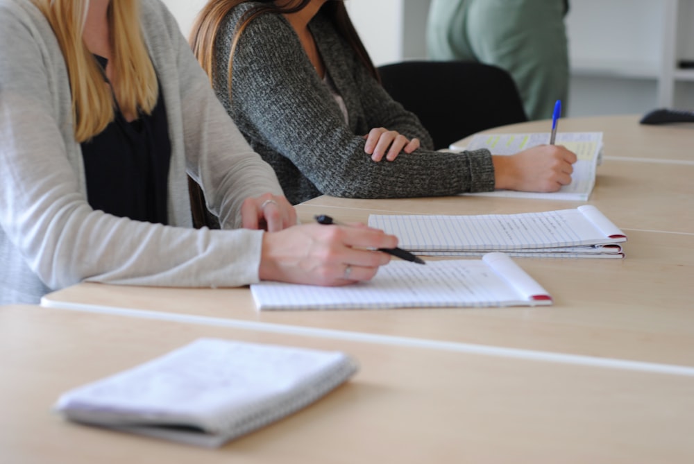 a woman writing on a piece of paper