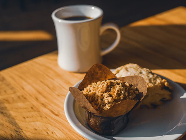 Taza de café acompañada de alimentos en una cafetería
