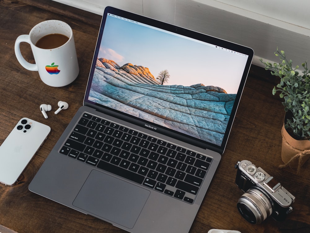 a laptop computer with a coffee cup